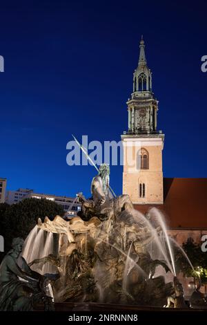 Berlin, Allemagne, Fontaine de Neptune (Neptunbrunnen) à partir de 1891 et St. L'église Marie (Marienkirche) illuminée la nuit. Banque D'Images