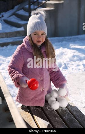 Adorable petite fille jouant avec le snowball Maker à l'extérieur Banque D'Images