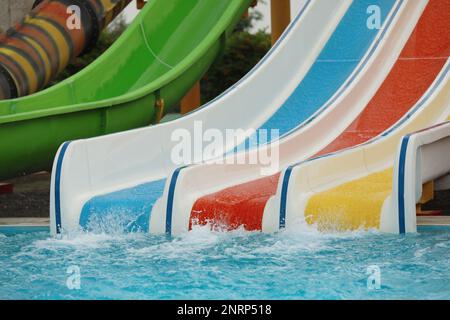 Toboggans colorés près de la piscine dans le parc aquatique Banque D'Images