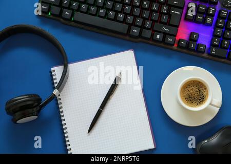 Clavier moderne avec éclairage RVB et papeterie sur fond bleu, pose plate Banque D'Images
