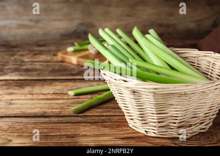 Citronnelle fraîche dans un bol en osier sur une table en bois, espace pour le texte Banque D'Images