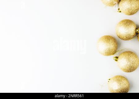 Boules de noël dorées sur fond gris avec paillettes. Composition de Noël. Concept de fête de Noël, calamar de Noël et d'hiver Banque D'Images