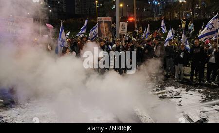 TEL AVIV, ISRAËL - FÉVRIER 25 : des membres des forces de sécurité israéliennes affrontent des manifestants antigouvernementaux après avoir allumé le feu et bloqué l'autoroute Ayalon, L'une des principales autoroutes d'Israël lors d'une manifestation contre la nouvelle coalition de droite du Premier ministre Benjamin Netanyahou et ses propositions de changements judiciaires visant à affaiblir la Cour suprême du pays sur le 25 février 2023 à tel-Aviv, en Israël. Des dizaines de milliers de personnes se rassemblent pour la huitième semaine consécutive à travers Israël contre la vaste réforme controversée du système juridique israélien qui relancerait le pouvoir des élus Banque D'Images