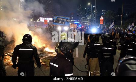 TEL AVIV, ISRAËL - FÉVRIER 25 : des membres des forces de sécurité israéliennes affrontent des manifestants antigouvernementaux après avoir allumé le feu et bloqué l'autoroute Ayalon, L'une des principales autoroutes d'Israël lors d'une manifestation contre la nouvelle coalition de droite du Premier ministre Benjamin Netanyahou et ses propositions de changements judiciaires visant à affaiblir la Cour suprême du pays sur le 25 février 2023 à tel-Aviv, en Israël. Des dizaines de milliers de personnes se rassemblent pour la huitième semaine consécutive à travers Israël contre la vaste réforme controversée du système juridique israélien qui relancerait le pouvoir des élus Banque D'Images