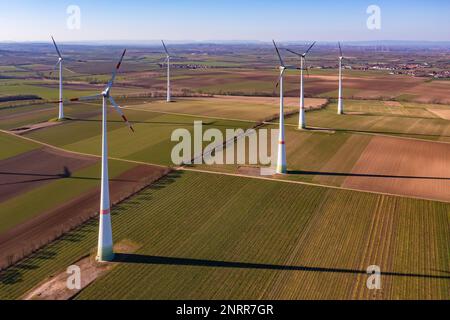 Vue aérienne des grandes éoliennes entre les champs sous le soleil d'hiver Banque D'Images