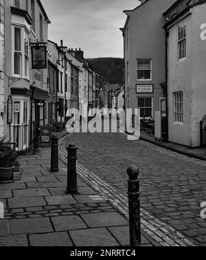 Photo en noir et blanc de la charmante rue principale pavée de Staithes, dans le Yorkshire. Banque D'Images