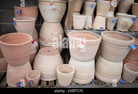 Une grande pile de pots en céramique de terre cuite marron pour planter dans un centre de jardin à des prix de vente Banque D'Images