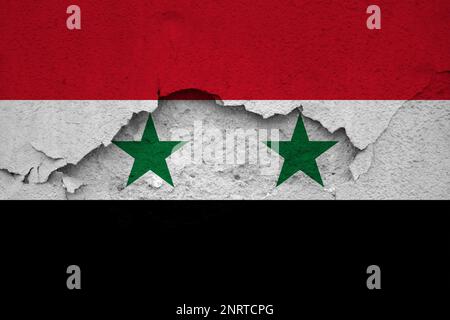 Tremblements de terre en Syrie, drapeau de la Syrie sur un mur avec des fissures d'un tremblement de terre Banque D'Images