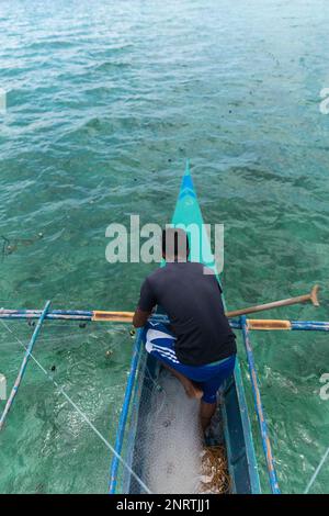 photo verticale du pêcheur collectant le filet de pêche, philippines Banque D'Images