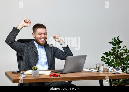 homme assis sur une chaise à la table et reposant, à l'aide d'un ordinateur portable Banque D'Images