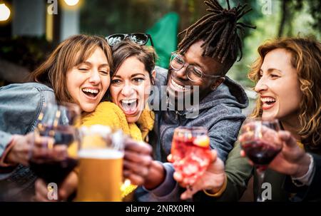 Les jeunes s'amusent à boire à la maison dîner barbecue fête - les personnes de la gamme d'âge mixte toaster des boissons dans le jardin du restaurant chic ensemble Banque D'Images