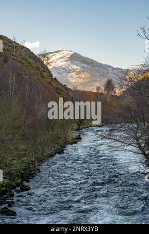 En regardant vers le sud le long d'Afon Glasyn depuis Llyn Dinas, près de Beddgelert, au nord du pays de Galles vers les arbres et les collines de Snowdonia sud. par une belle journée d'hiver. Banque D'Images