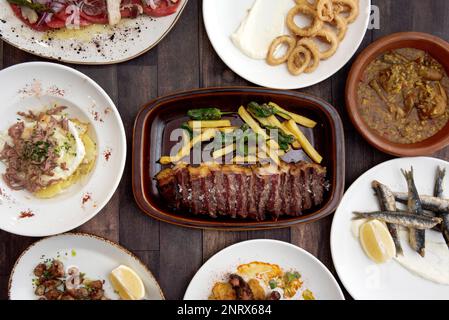 Ensemble de plats avec recettes de tapas espagnoles avec anchois frits, poulpe grillée, rôti de bœuf haché avec des patatas et des poivrons, salade ventresco an Banque D'Images