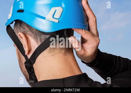 Homme, touriste, grimpeur. Tourne un casque, un casque de protection. Dans les montagnes. Hauteur. Banque D'Images