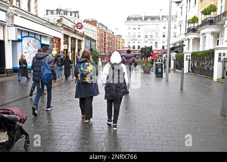 Vue arrière de la mère et de l'adolescent fils garçon 13 personnes visiteurs marchant dans la rue Londres pendant la pause scolaire de mi-mandat février 2023 UK KATHY DEWITT Banque D'Images