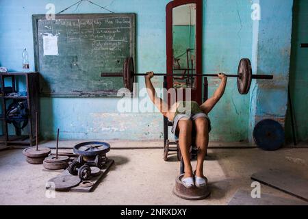 Un homme ne Cubaine de l'exercice dans une salle de sport, musculation dans la rue San Rafael, Centro Habana, La Havane, Cuba Banque D'Images