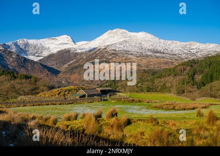 En regardant vers le Mont Snowdon depuis la route de campagne au-dessus de Llyn Dinas, près de Beddgelert, au nord du pays de Galles, par une belle journée d'hiver. Banque D'Images