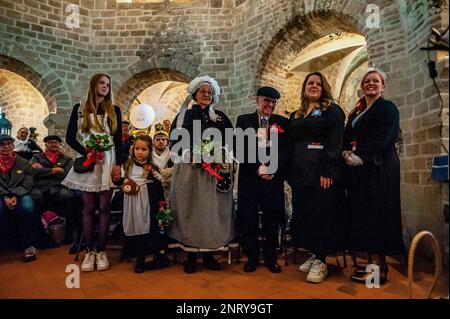 Le couple avec leurs filles et leur petite-fille a vu écouter le discours du faux prêtre. La tradition du faux mariage paysan pendant le carnaval remonte au XVIe siècle, la noblesse a joué le rôle des paysans et les paysans étaient les seigneurs. À Nijmegen, Anja et Theo Wijlemans étaient le couple de mariage de l'agriculteur cette année. Le couple s'est rassemblé à la chapelle de Valkhof, portant des vêtements de fermiers traditionnels et entouré de personnes portant des costumes vibrants. Le mariage de l'agriculteur est l'une des traditions du Carnaval néerlandais, en particulier à Limbourg, Brabant du Nord et Gelderland. Banque D'Images