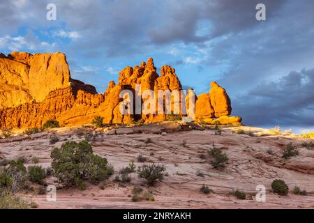 Ciel orageux au-dessus des formations de grès Entrada des Navajo Rocks au coucher du soleil près de Moab, Utah. Banque D'Images