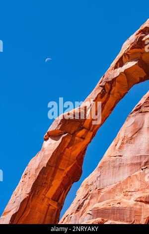 Faites une lune au-dessus de la Jog Handle Arch, une arche presque verticale en grès Wingate, près de la rivière Colorado, près de Moab, Utah. Banque D'Images