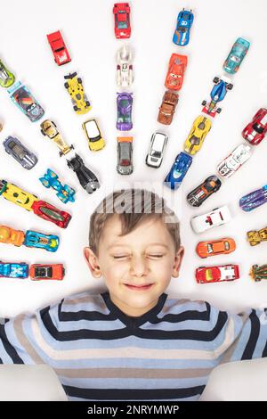 Portrait d'un enfant du Caucase avec des voitures jouets sur blanc Banque D'Images