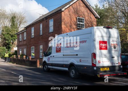 Camion de livraison Argos stationné dans un village du Hampshire avec un livreur, Angleterre, Royaume-Uni Banque D'Images