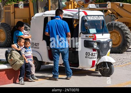 Une famille à côté d'un mototaxi à Santiago Matatlan dans les vallées centrales d'Oaxaca, au Mexique. Banque D'Images