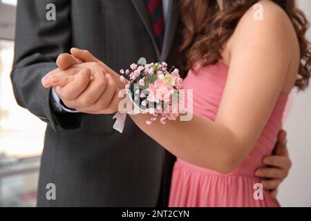Le jeune homme et son proéminent date avec la fleur en relief tenant les mains, gros plan Banque D'Images