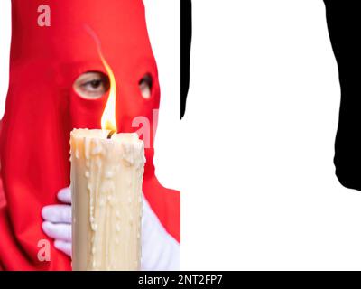 La bougie dans la flamme d'un Nazaréen avec une cagoule rouge faisant sa station de pénitence dans la procession de la semaine sainte.foyer sélectif avec flamme de bougie seulement dans le foyer Banque D'Images