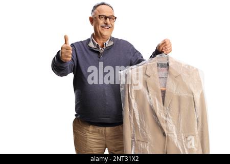 Homme mature collectant le costume des nettoyeurs à sec et en faisant des gestes isolés sur un fond blanc Banque D'Images