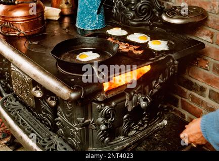 Le petit-déjeuner est cuisiné sur une vieille cuisinière en bois. Banque D'Images
