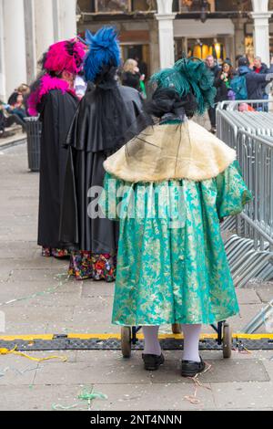 Venise, Italie - 21 février 2023 : dame âgée vêtue d'un masque traversant la Piazza San Marco à Venise. Banque D'Images