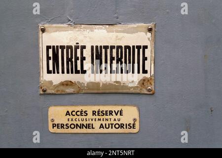 Deux panneaux sur une porte avec l'inscription française « entrée interdite » (entrée interdite) sur la première et « accès refusé au personnel autorisé » Banque D'Images