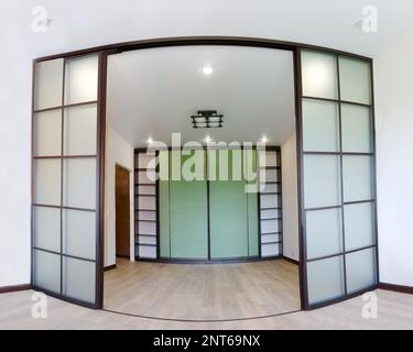 Photo grand angle de la réparation de l'intérieur d'un nouveau salon avec portes coulissantes coupé dans le style japonais Shoji avec une armoire. Design asiatique moderne Banque D'Images