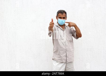 Latino âgés avec masques protecteurs sur fond de mur blanc, nouveau normal Covid-19 Banque D'Images