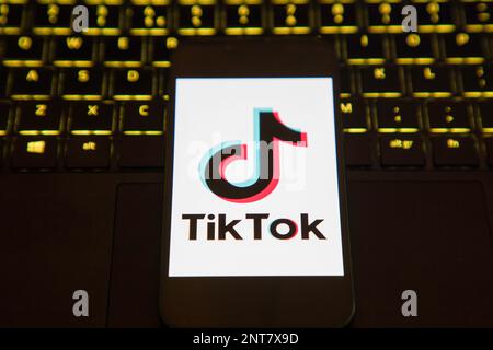 Écran de chargement de l'application Tik Tok sur un téléphone portable installé sur un ordinateur portable éclairé Banque D'Images