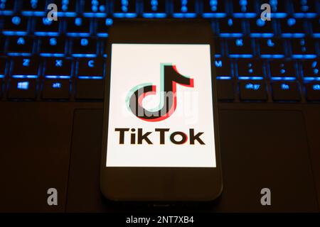 Écran de chargement de l'application Tik Tok sur un téléphone portable installé sur un ordinateur portable éclairé Banque D'Images