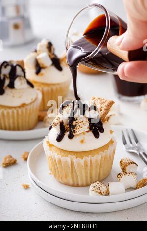 Smores cupcakes aux petits guimauves, biscuits graham à la chapelure et au sirop de chocolat Banque D'Images