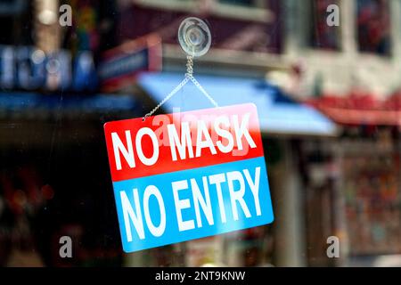 Signe rouge et bleu dans la fenêtre d'un magasin disant "pas de masque, pas d'entrée". Banque D'Images