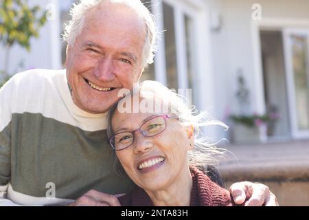 Joyeux couple senior divers embrassant et souriant dans le jardin Banque D'Images