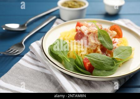 Courge spaghetti savoureuse au bacon et au basilic servi sur une table en bois bleu, en gros plan Banque D'Images