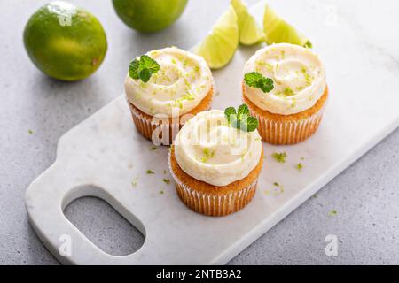Mojito cupcakes au citron vert et à la noix de coco garni de feuilles de menthe Banque D'Images