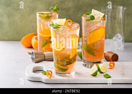 Cocktail de mojito à l'orange et au citron vert dans de grands verres avec citron vert et menthe fraîche Banque D'Images