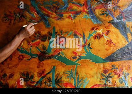 Yogyakarta, Indonésie. 27th févr. 2023. Un artisan travaille sur un batik dessiné à la main pour une décoration murale à la galerie Batik Seno, Yogyakarta. Les batiks décoratifs se vendent pour quelque chose entre 150 000 à 3 millions de roupies indonésiennes (environ US$ 10-200) selon la taille et la qualité. La galerie propose également des forfaits d'apprentissage batik pour les touristes étrangers. (Photo par Angga Budhiyanto/SOPA Images/Sipa USA) crédit: SIPA USA/Alay Live News Banque D'Images