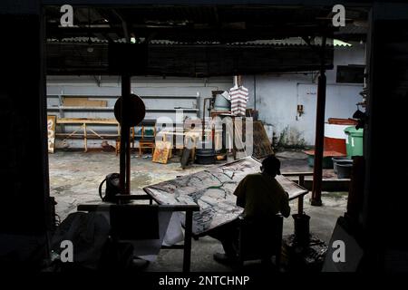 Yogyakarta, Indonésie. 27th févr. 2023. Un artisan travaille sur un batik dessiné à la main pour une décoration murale à la galerie Batik Seno, Yogyakarta. Les batiks décoratifs se vendent pour quelque chose entre 150 000 à 3 millions de roupies indonésiennes (environ US$ 10-200) selon la taille et la qualité. La galerie propose également des forfaits d'apprentissage batik pour les touristes étrangers. (Photo par Angga Budhiyanto/SOPA Images/Sipa USA) crédit: SIPA USA/Alay Live News Banque D'Images