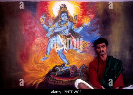 Un homme assis près de la fresque du Seigneur shiva dans le temple de Wadakancherry Siva, Kerala, Inde, Asie Banque D'Images