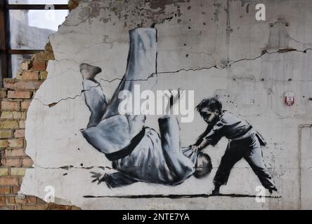 Borodyanka, Ukraine. 26th févr. 2023. Le travail de l'artiste anglais Banksy est vu sur un mur détruit, après que la Fédération de Russie a attaqué la ville de Borodyanka, les autorités ont décidé de sauver le travail de Banksy et maintenant ils sont protégés par le système de garde. Crédit : SOPA Images Limited/Alamy Live News Banque D'Images