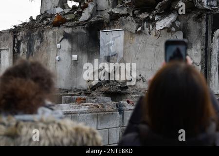 Borodyanka, Ukraine. 26th févr. 2023. Une femme prend des photos du travail de Banksy avec son téléphone, le travail de l'artiste anglais Banksy est visible sur le mur détruit, après que la Fédération de Russie a attaqué la ville de Borodyanka, les autorités ont décidé de sauver le travail de Banksy et maintenant ils sont protégés par le système. (Photo de Maksym Polischchuk/SOPA Images/Sipa USA) crédit: SIPA USA/Alay Live News Banque D'Images
