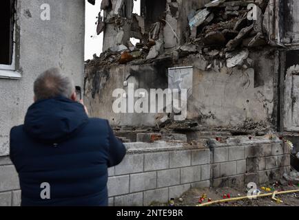 Borodyanka, Ukraine. 26th févr. 2023. Un homme prend des photos du travail de Banksy avec son téléphone, le travail de l'artiste anglais Banksy est visible sur le mur détruit, après que la Fédération de Russie a attaqué la ville de Borodyanka, les autorités ont décidé de sauver le travail de Banksy et maintenant ils sont protégés par le système. (Photo de Maksym Polischchuk/SOPA Images/Sipa USA) crédit: SIPA USA/Alay Live News Banque D'Images