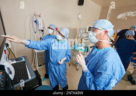 Le travail d'équipe est essentiel pour sauver des vies. une équipe de chirurgiens discutant des examens médicaux d'un patient pendant la chirurgie. Banque D'Images